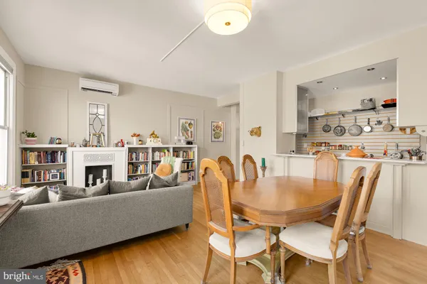 a living room with furniture and a dining table with wooden floor