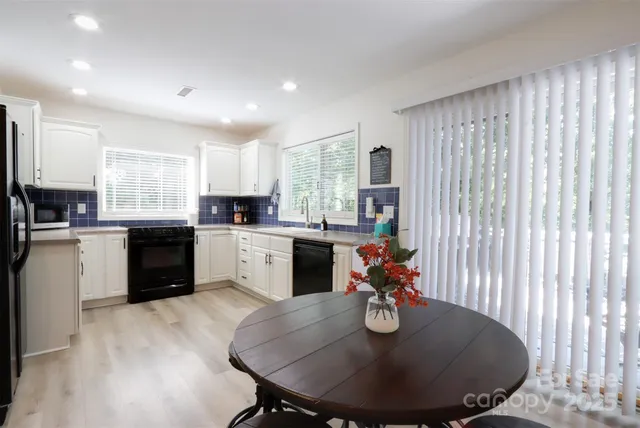a kitchen with kitchen island granite countertop stainless steel appliances a sink dining table and chairs