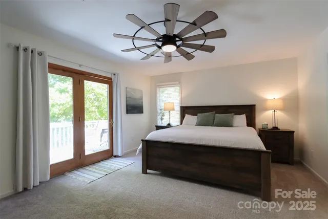 a bedroom with a bed chandelier and window