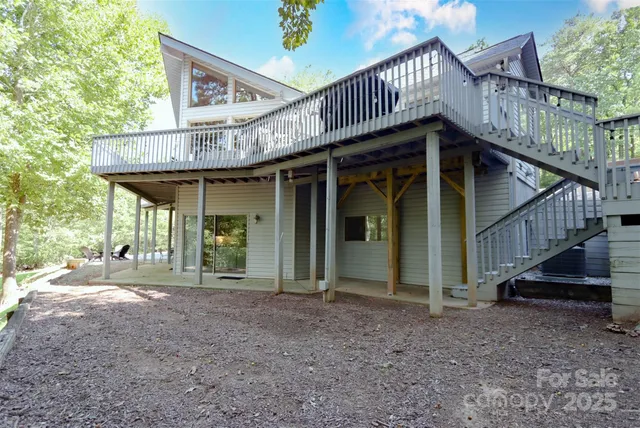 a view of a house with wooden deck and a backyard