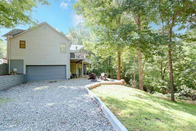a view of a house with a yard and large tree