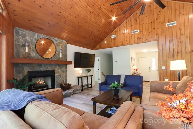 a living room with furniture a fireplace and a flat screen tv