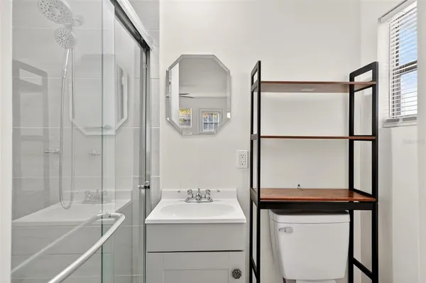 a bathroom with a shower a sink and mirror