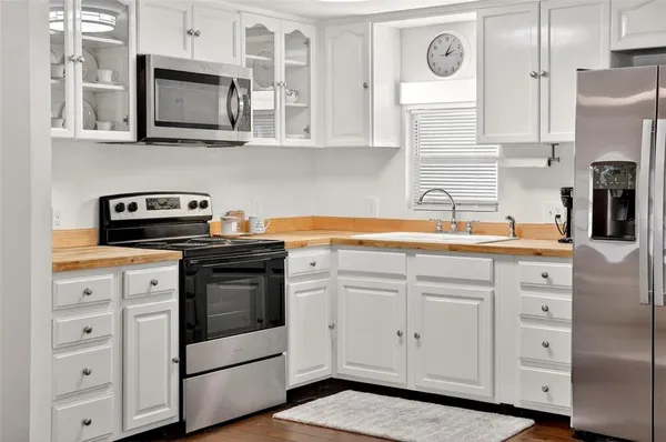 a kitchen with white cabinets stainless steel appliances and sink