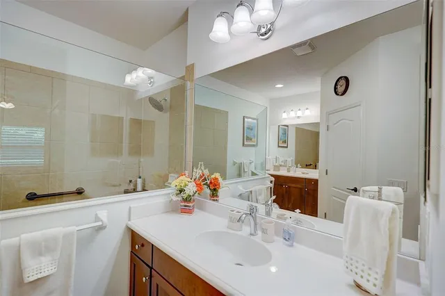 a spacious bathroom with a double vanity sink a large mirror and a bathtub