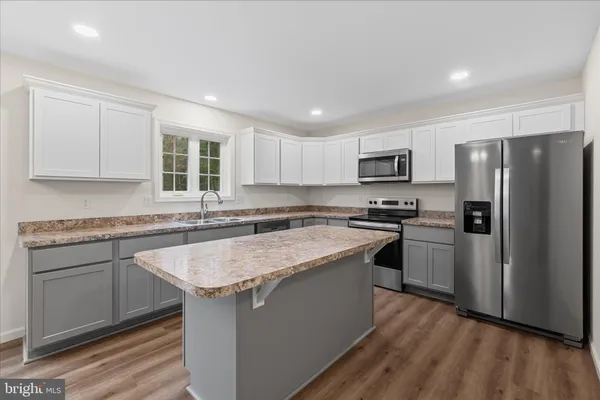 a kitchen with a refrigerator stove microwave and sink