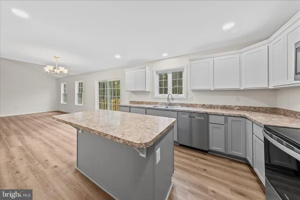 a kitchen with granite countertop sink stove and cabinets