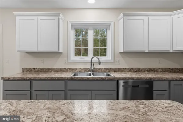 a kitchen with granite countertop a sink and a stove