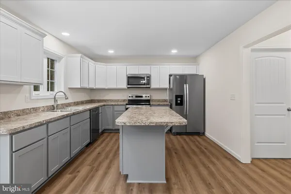 a kitchen with stainless steel appliances granite countertop a sink stove refrigerator and cabinets