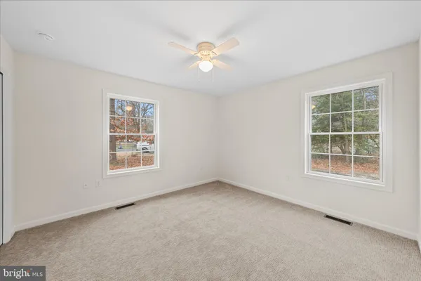 an empty room with a window and a ceiling fan