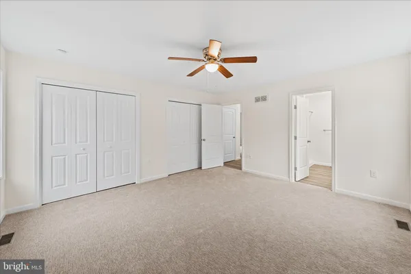 an empty room with closet and windows