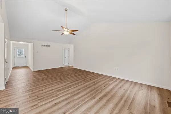 a view of a livingroom with wooden floor and a ceiling fan