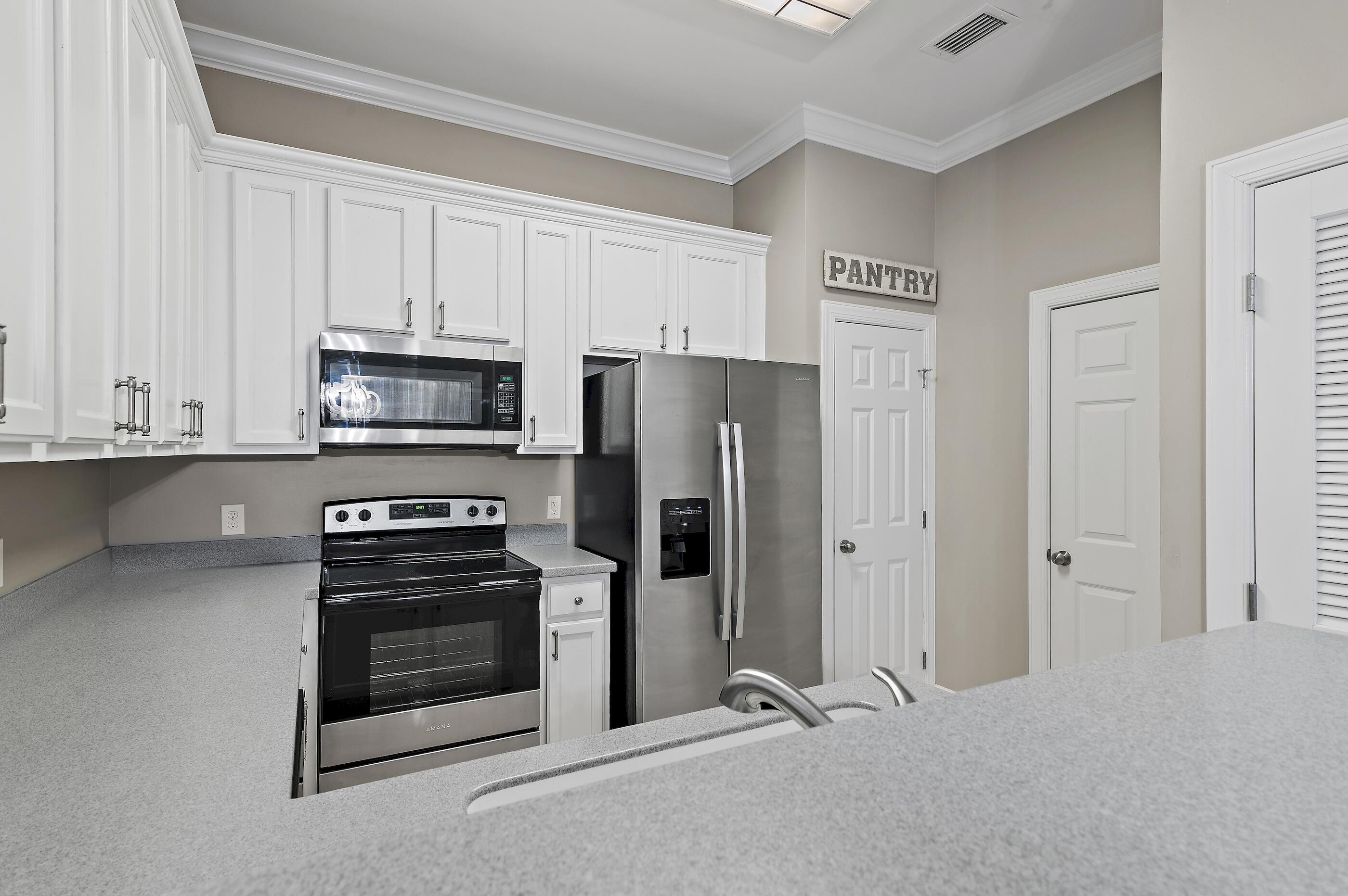 231 Somerset Bridge Road, Unit 2107 Santa Rosa Beach, FL 32459 - Photo 8 of 47 a kitchen with stainless steel appliances a refrigerator stove and white cabinets