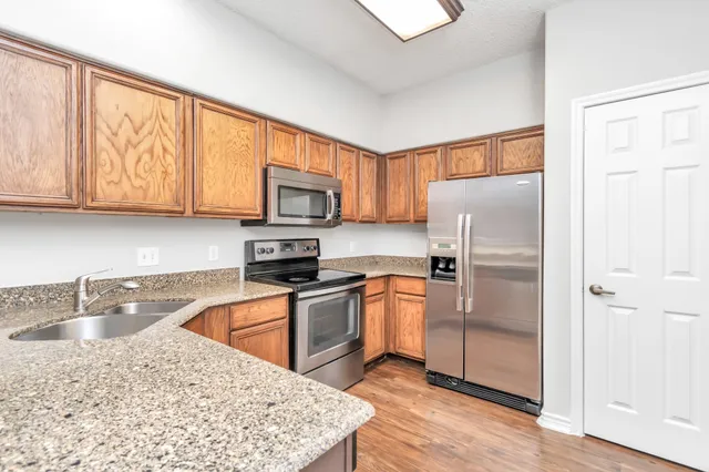 a kitchen with stainless steel appliances granite countertop a refrigerator sink and stove