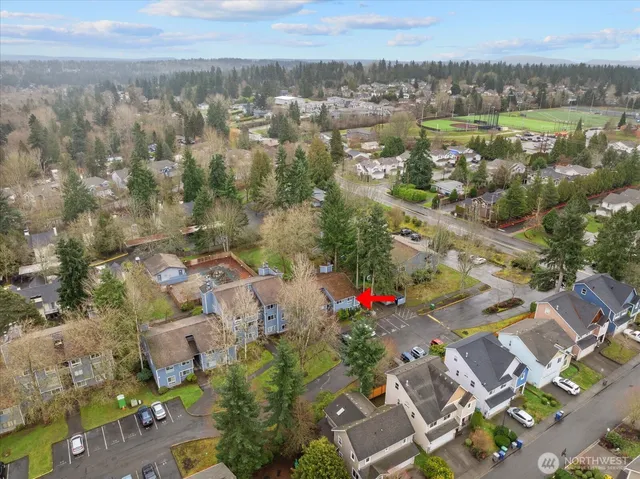 an aerial view of residential houses with outdoor space and trees