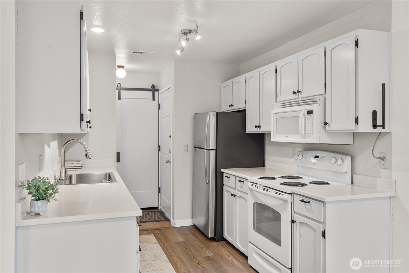 4120 212th Street Southwest, Unit B206 Mountlake Terrace, WA 98043 - Photo 4 of 20 a kitchen with white cabinets and white appliances