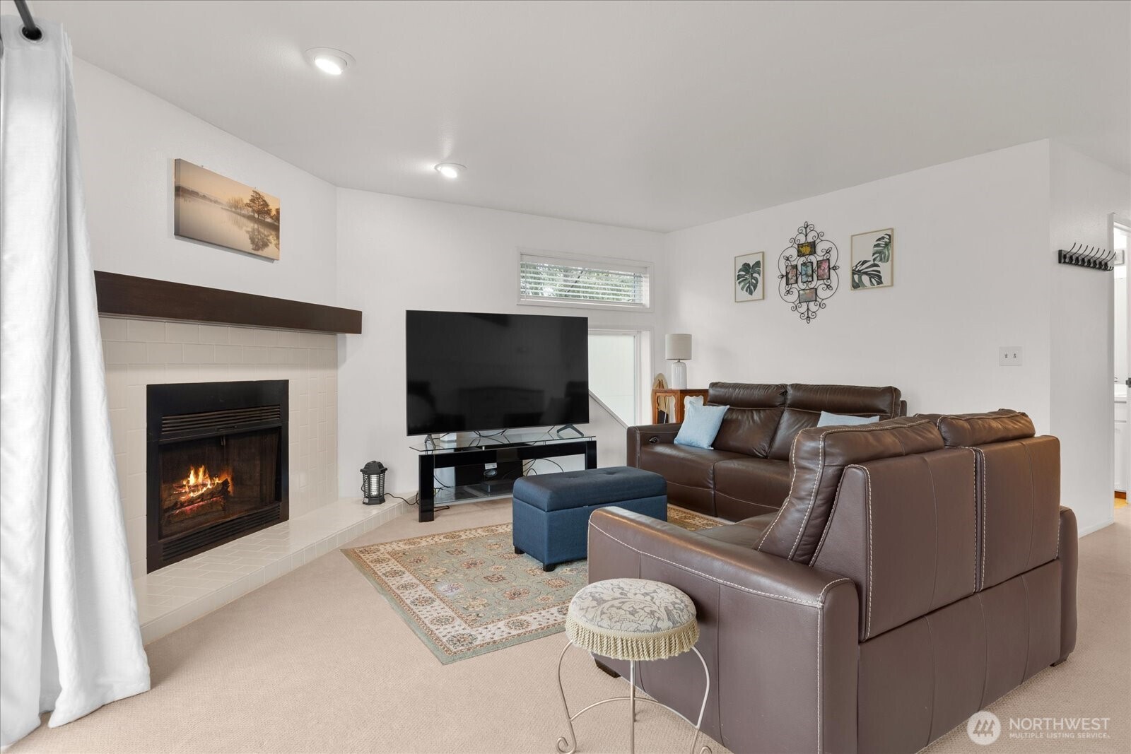 4120 212th Street Southwest, Unit B206 Mountlake Terrace, WA 98043 - Photo 6 of 20 a living room with furniture a flat screen tv and a fireplace