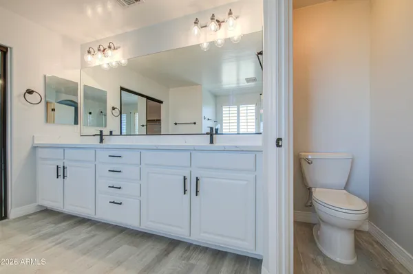 a spacious bathroom with a granite countertop sink a toilet and a mirror