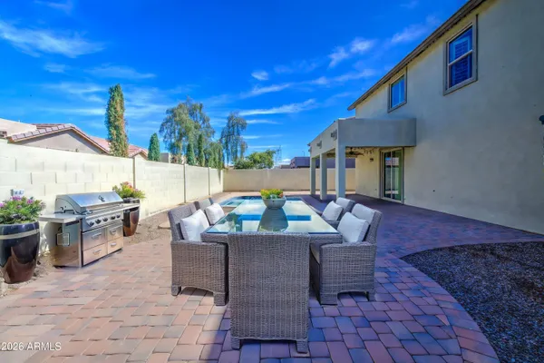 a view of a patio with couches and table and chairs with wooden fence