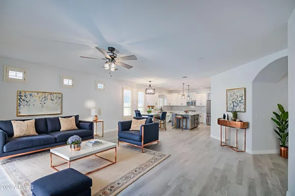 a living room with furniture kitchen view and a chandelier