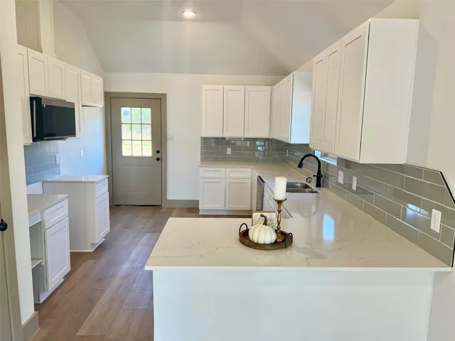 a kitchen with a sink a stove and cabinets