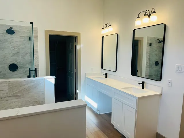a bathroom with double vanity sinks and a mirror
