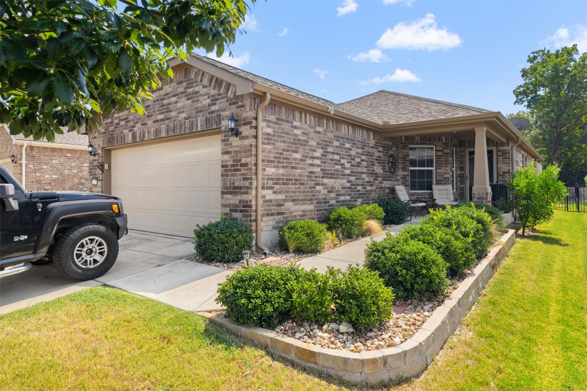 a view of a house with small yard plants and a patio