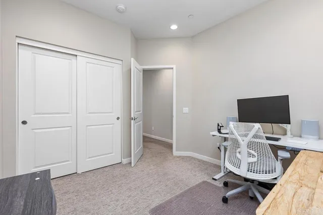 a view of a workspace with furniture and a window