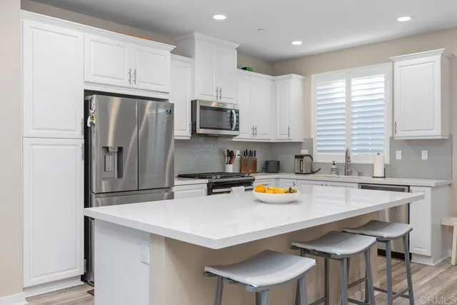 a kitchen with a sink a kitchen island and stainless steel appliances