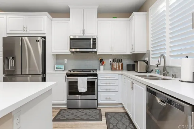a kitchen with stainless steel appliances a stove microwave and sink
