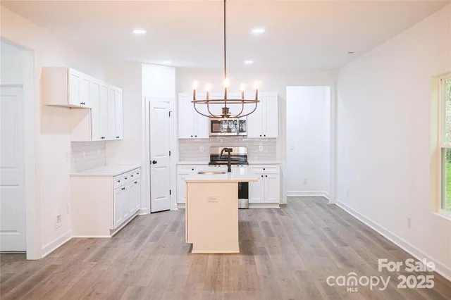 a kitchen with stainless steel appliances a refrigerator and wooden floor