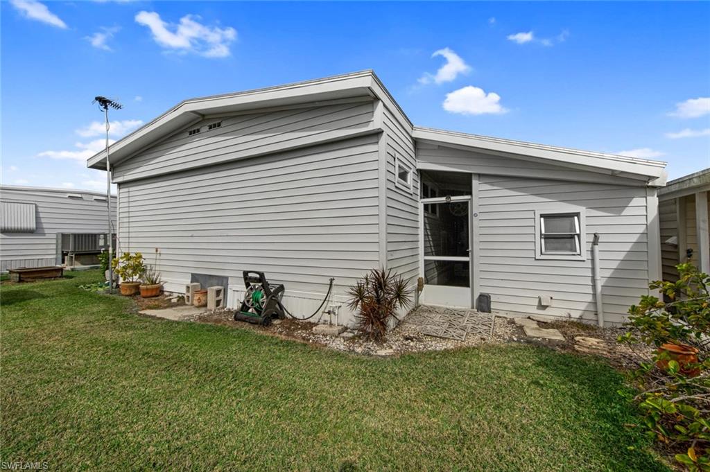 28 Enchanting Boulevard, Unit E28 Naples, FL 34112 - Photo 27 of 28 a backyard of a house with table and chairs