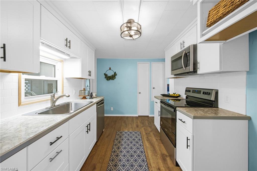 28 Enchanting Boulevard, Unit E28 Naples, FL 34112 - Photo 4 of 28 a kitchen with granite countertop a sink stainless steel appliances and cabinets