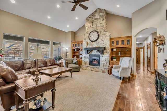 896 West 675 South Mapleton, UT 84664 - Photo 3 of 77 Living area with high vaulted ceiling, a stone fireplace, hardwood / wood-style flooring, arched walkways, and ceiling fan