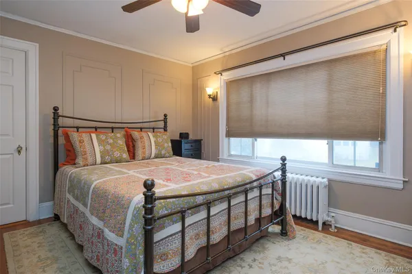 a bedroom with a bed a chandelier and a window