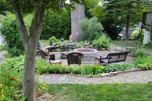 a backyard of a house with table and chairs and potted plants