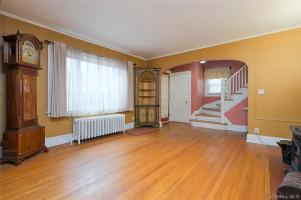 a view of an empty room with stairs and a window