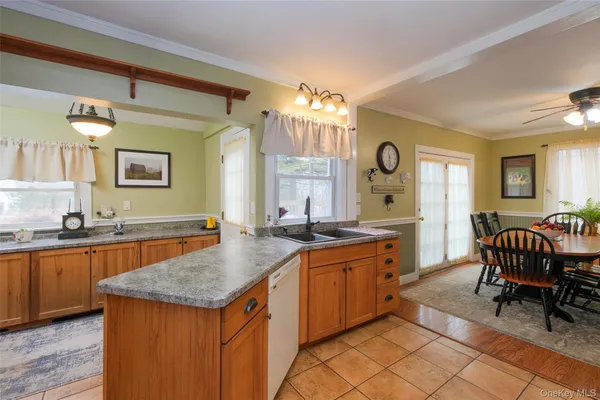 a kitchen with granite countertop a sink and chairs