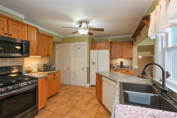a kitchen with stainless steel appliances granite countertop a sink stove refrigerator and cabinets