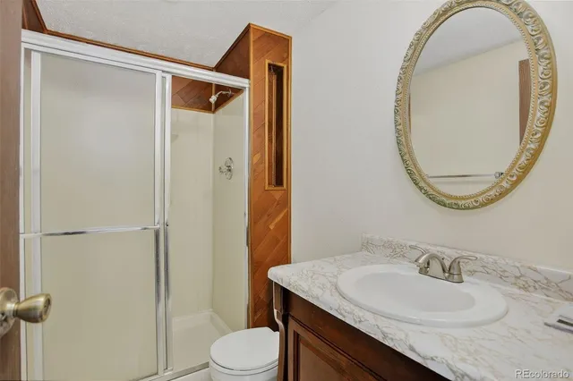 a bathroom with a granite countertop sink mirror vanity and toilet