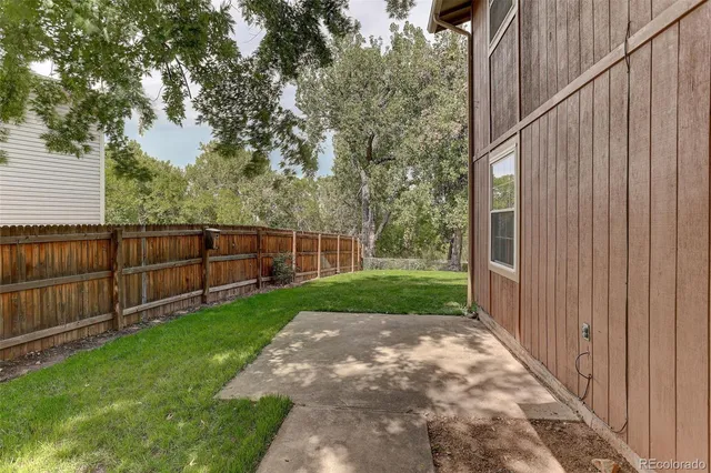 a view of a backyard with wooden fence