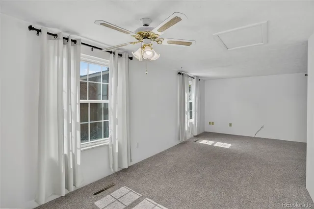 a view of a livingroom with a ceiling fan and window