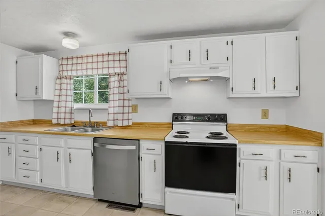 a kitchen with granite countertop white cabinets and white appliances
