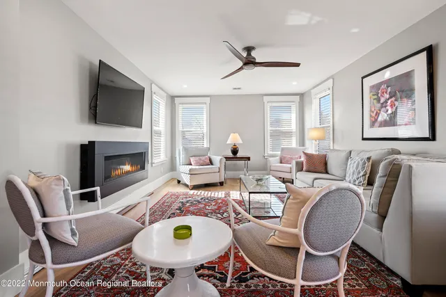 a living room with furniture a flat screen tv and a fireplace