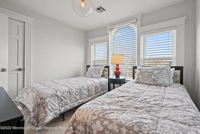 a bedroom with two beds and a large mirror