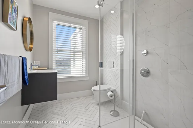 a bathroom with a sink a toilet and shower