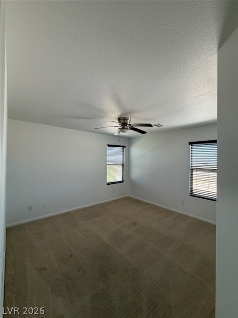3862 Landing Ridge Place Las Vegas, NV 89135 - Photo 19 of 26 A well-lit bedroom features plush carpeting and a modern ceiling fan, offering a comfortable personal retreat.