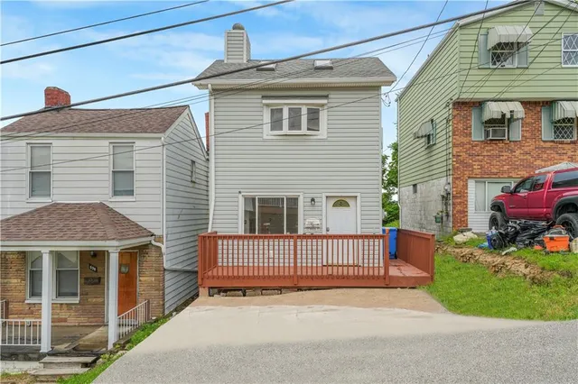 a view of a house with a yard and potted plants