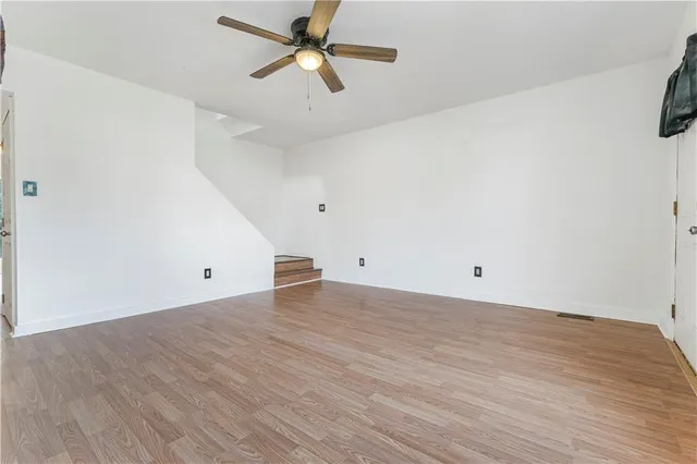 a view of a room with wooden floor and a ceiling fan