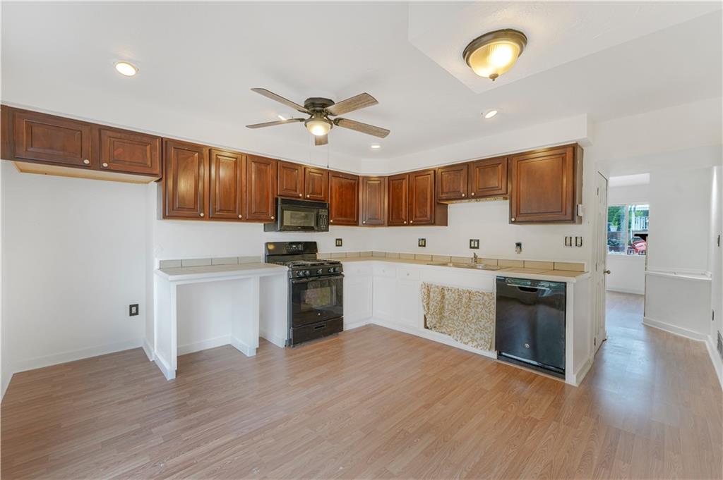 534 Magazine Street Carnegie, PA 15106 - Photo 4 of 11 a kitchen with granite countertop a refrigerator a stove top oven a sink dishwasher and wooden floor